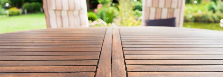 Leere Holztischplatte im Garten